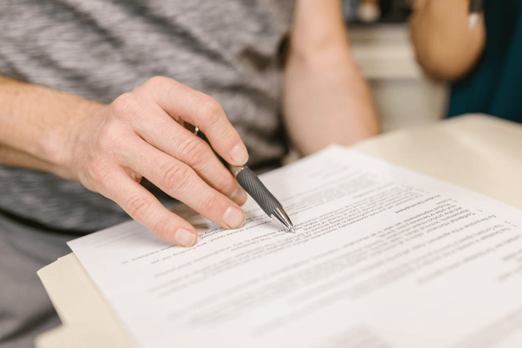 An image of a woman holding a pen as she read the papers