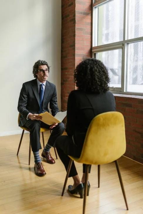 An image of a Dallas woman and man looking at each other while sitting on chairs      