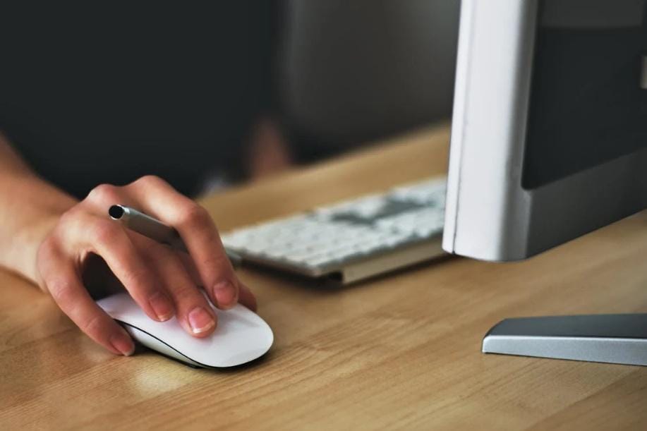 An image of a person using a computer at their desk    