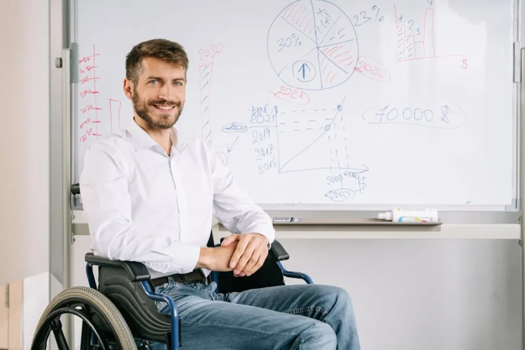 A man smiling next to a whiteboard