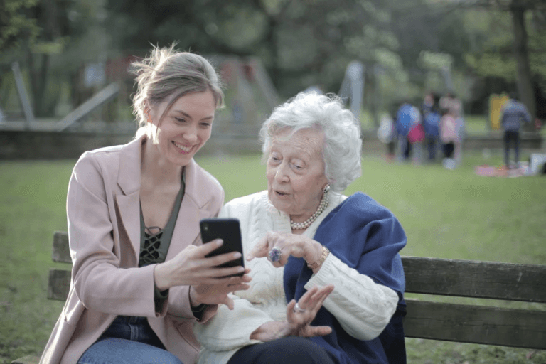 :A person showing something to a senior on their phone