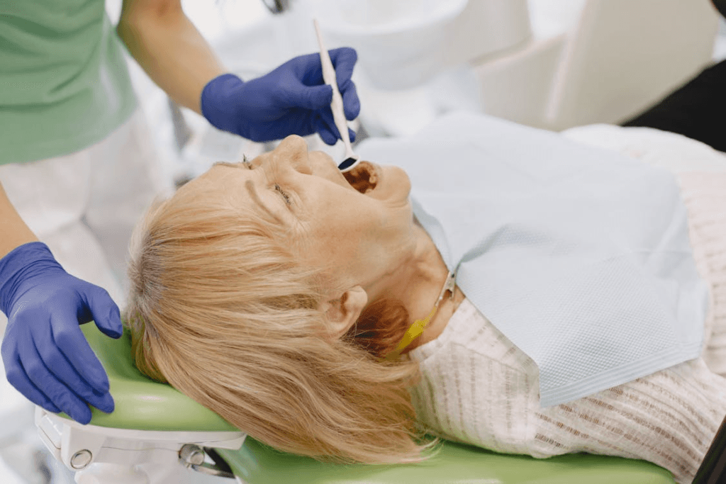 an old woman wearing a white shirt at a dentist getting her teeth checked