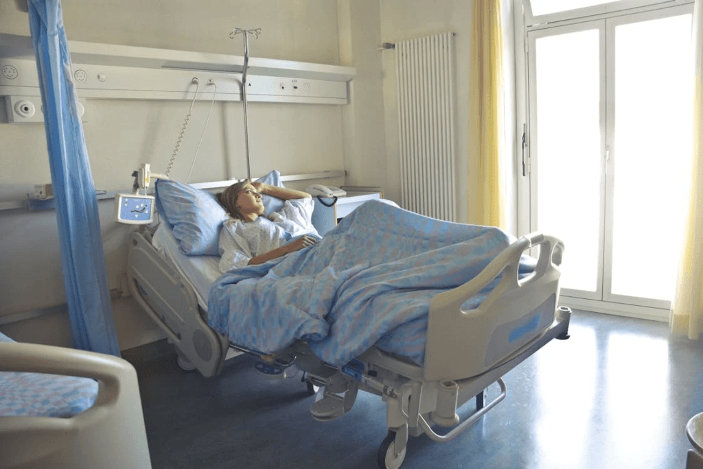 a patient in hospital clothes lying in a private hospital room bed