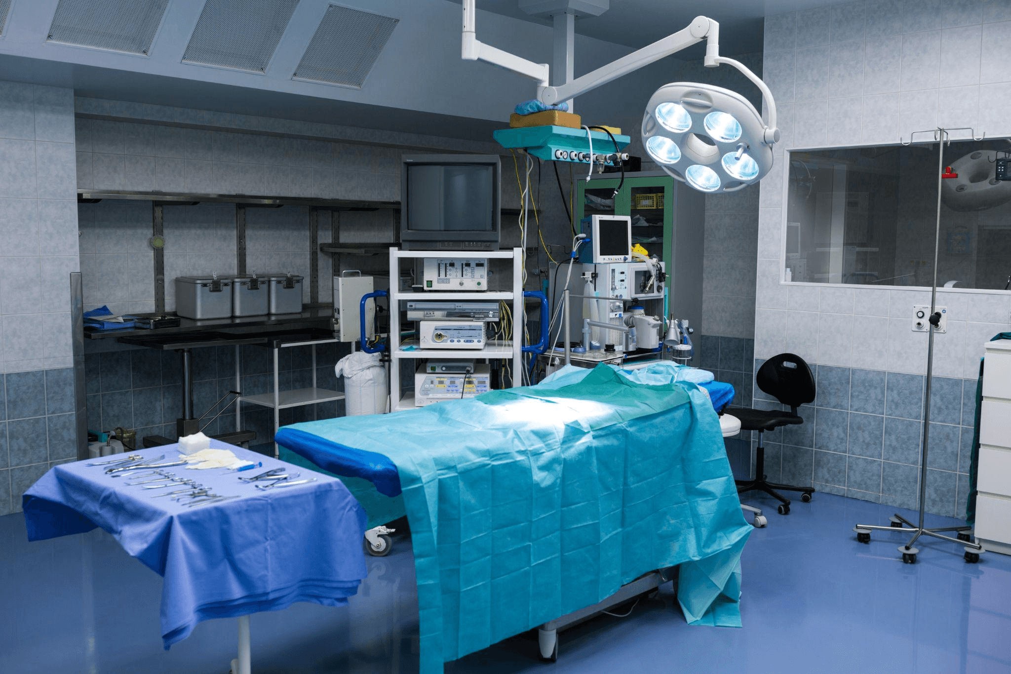 a sanitized and empty hospital room with a stretcher and medical equipment around it