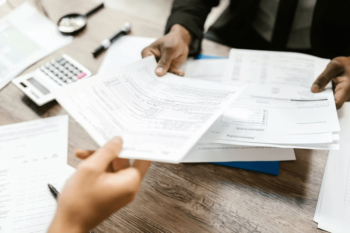 a client at an insurance company reviewing their insurance plan being handed over by an employee