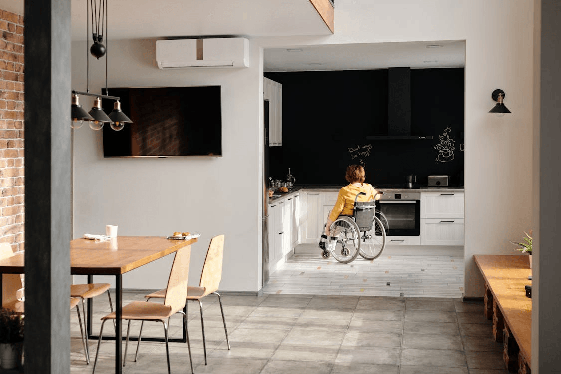 a woman in a wheelchair navigating her way through a kitchen