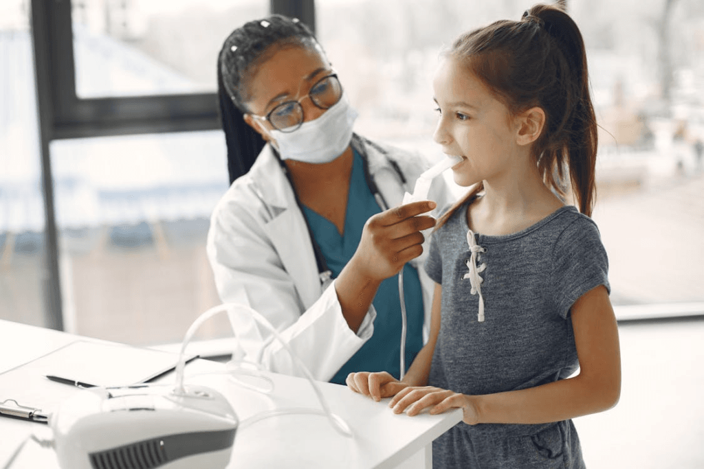 a pediatrician wearing a mask doing a little girl's checkup at the hospital