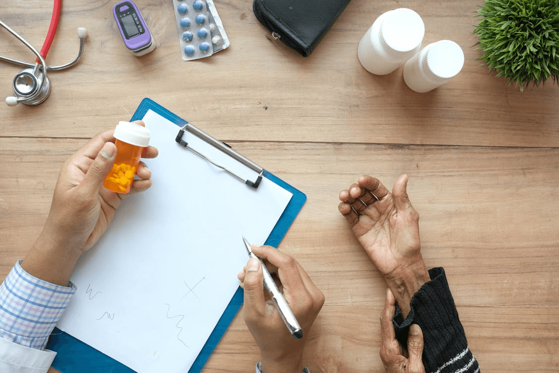 doctor prescribing medicine to a patient over a wooden table