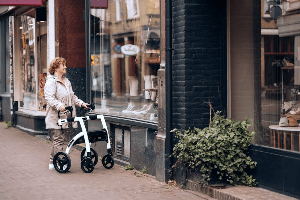 old woman walking down the street using a walker and looking into shops