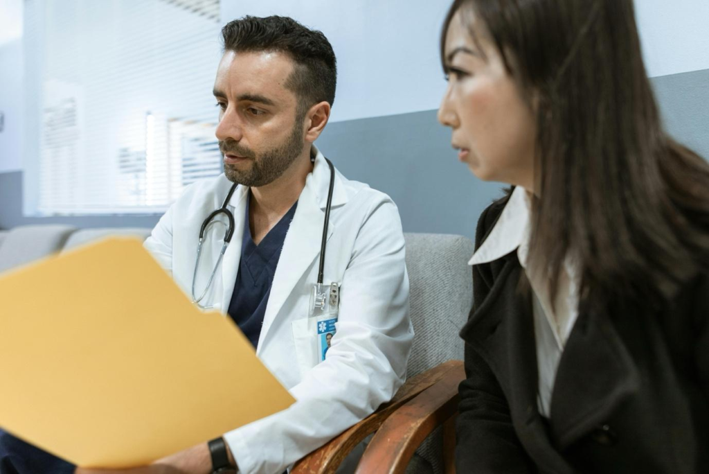 Male doctor reviewing a medical file with a female patient