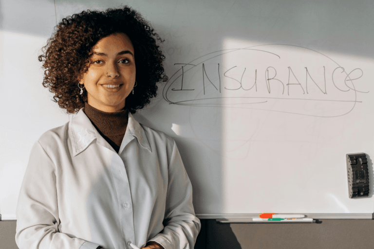 Woman standing in front of a whiteboard reading “insurance”